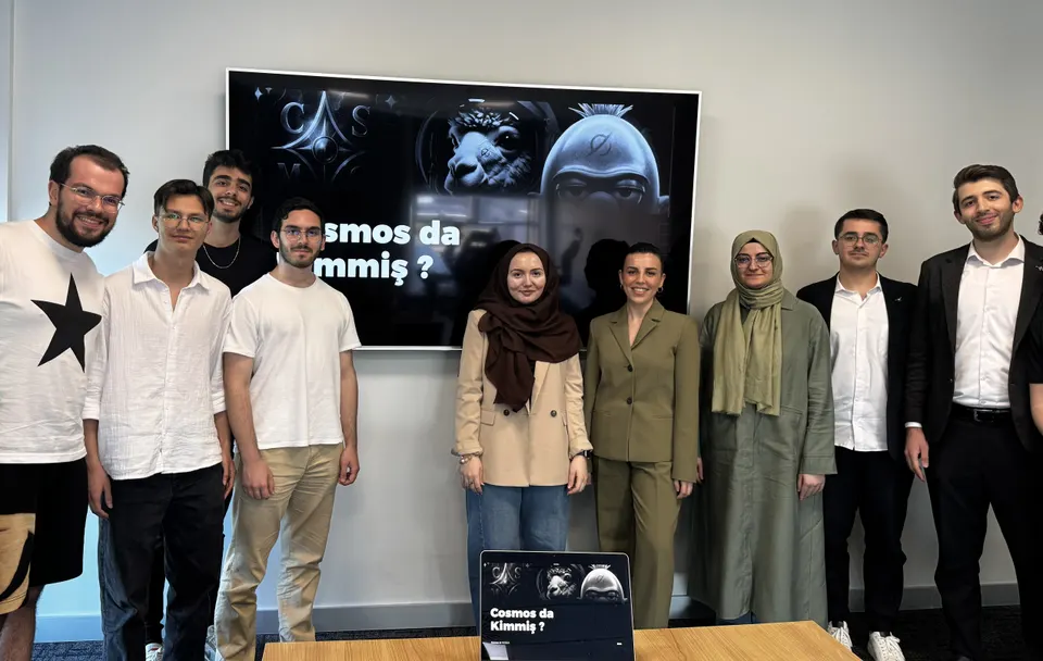 Group photo of presenters and hosts in front of a screen showing the slide "Cosmos da Kimmiş?"